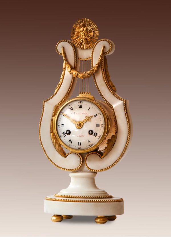 Lierpendule. Louis XVI-pendule in witmarmeren entourage in de vorm van een lier. Op de wijzerplaat gesigneerd Beliard Fils à Paris. ca. 1780.